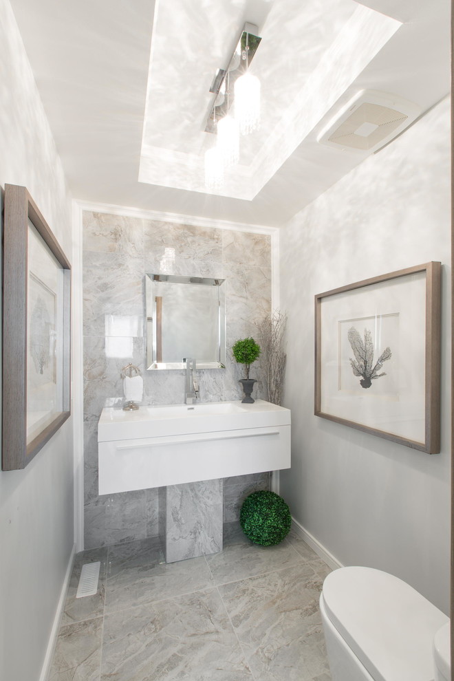 Inspiration for a small classic cloakroom in Edmonton with flat-panel cabinets, white cabinets, a one-piece toilet, grey tiles, porcelain tiles, grey walls, porcelain flooring, an integrated sink and solid surface worktops.