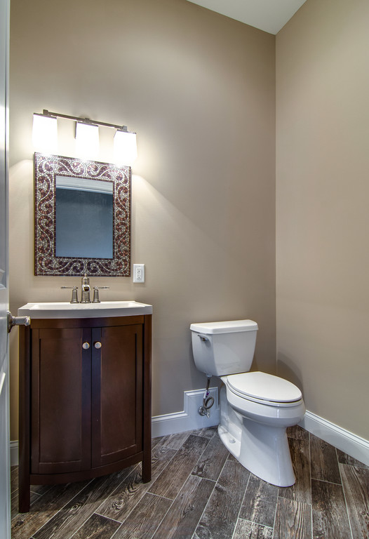 Exemple d'un petit WC et toilettes chic en bois foncé avec une vasque, WC séparés, un sol en carrelage de céramique, un mur beige et un placard à porte shaker.