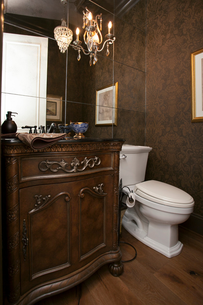 На фото: огромный туалет в викторианском стиле с врезной раковиной, темными деревянными фасадами, столешницей из гранита, раздельным унитазом, коричневыми стенами и паркетным полом среднего тона