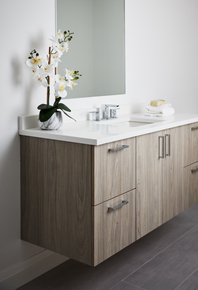Photo of a large traditional cloakroom in New York with beige cabinets, a two-piece toilet, grey walls, porcelain flooring, a submerged sink, grey floors, white worktops and a floating vanity unit.