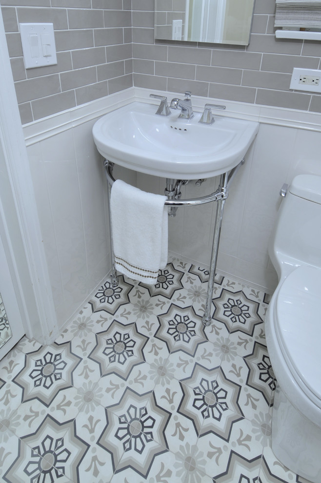 Cette photo montre un WC et toilettes chic de taille moyenne avec WC séparés, un carrelage beige, un carrelage métro, un mur beige, un sol en carrelage de céramique, une vasque et un sol multicolore.