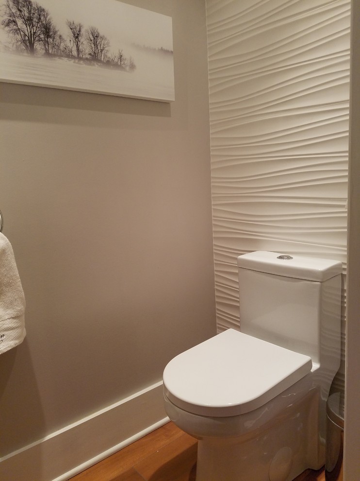 ニューヨークにある低価格の小さなコンテンポラリースタイルのおしゃれなトイレ・洗面所 (一体型トイレ	、白いタイル、磁器タイル、グレーの壁、セラミックタイルの床、壁付け型シンク) の写真
