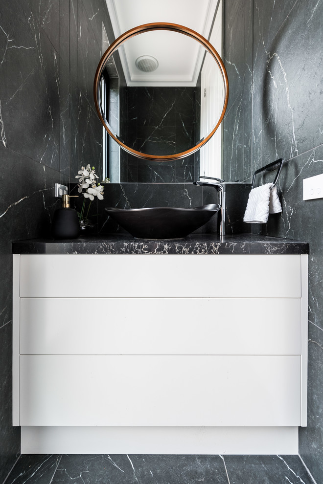 Photo of a small contemporary cloakroom in Melbourne with flat-panel cabinets, white cabinets, black and white tiles, ceramic tiles, black walls, porcelain flooring, a vessel sink, engineered stone worktops and black floors.