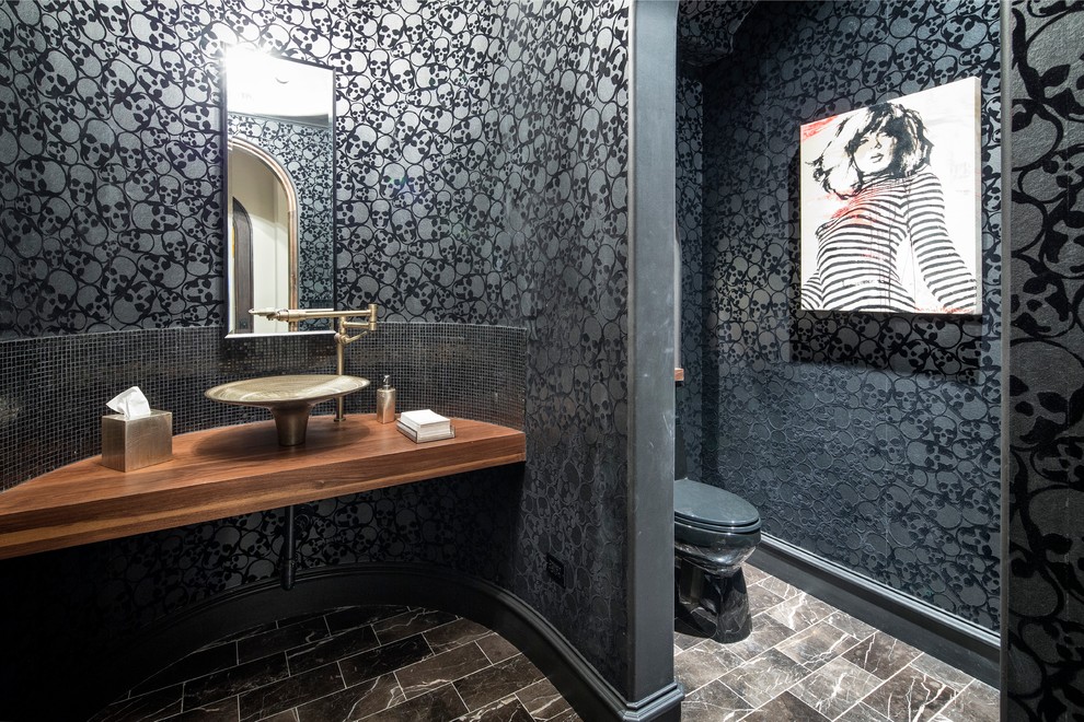 オースティンにあるインダストリアルスタイルのおしゃれなトイレ・洗面所 (ベッセル式洗面器、木製洗面台、黒いタイル、黒い壁、ブラウンの洗面カウンター) の写真