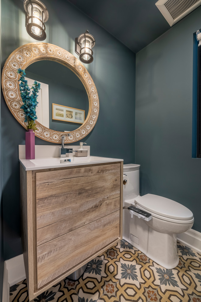 Immagine di un piccolo bagno di servizio minimal con ante lisce, ante in legno scuro, bidè, pareti blu, pavimento in cementine, lavabo integrato e pavimento multicolore
