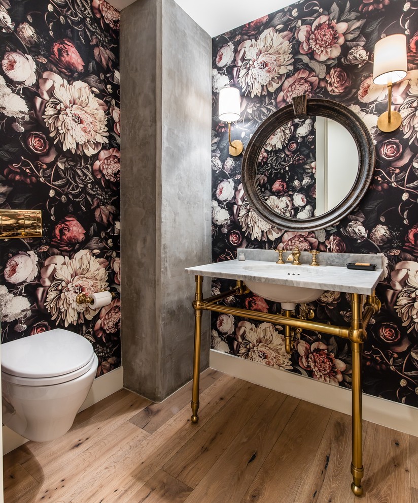 Classic cloakroom in Dallas with a wall mounted toilet, multi-coloured walls, light hardwood flooring, a console sink, brown floors and grey worktops.