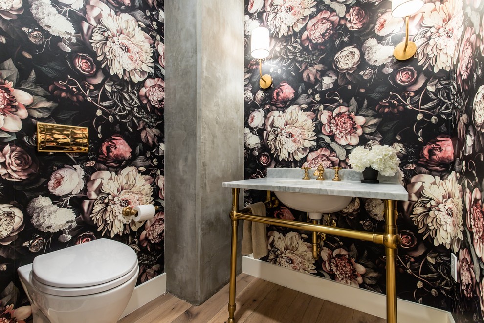 Cette photo montre un WC suspendu chic avec un mur multicolore, un sol en bois brun, un plan vasque, un plan de toilette en marbre, un sol beige et un plan de toilette gris.