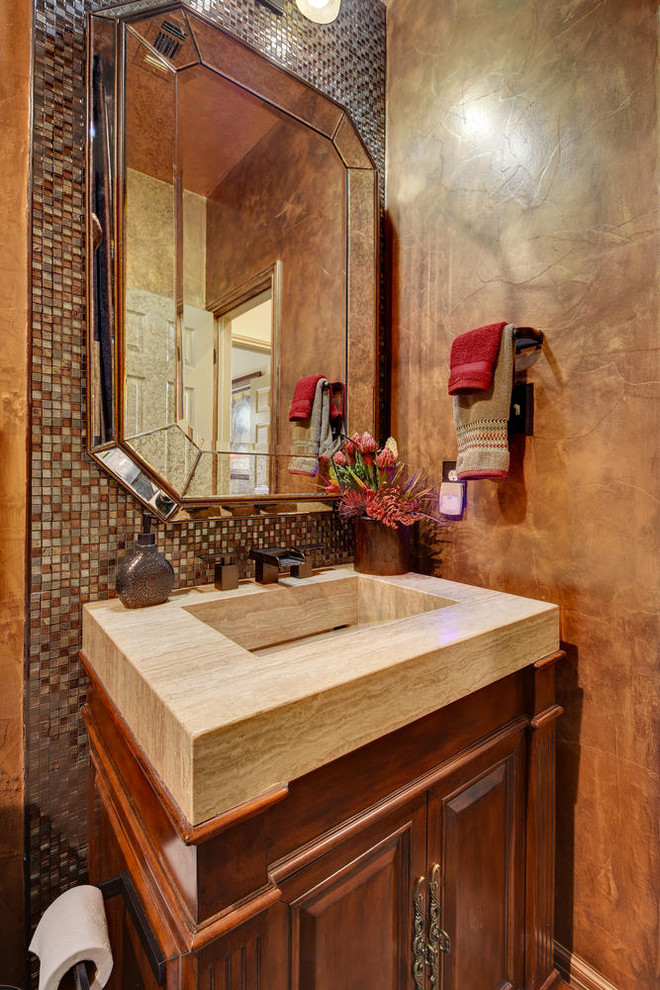 Mittelgroße Mediterrane Gästetoilette mit profilierten Schrankfronten, dunklen Holzschränken, farbigen Fliesen, Mosaikfliesen, brauner Wandfarbe, integriertem Waschbecken, Granit-Waschbecken/Waschtisch und beiger Waschtischplatte in Austin
