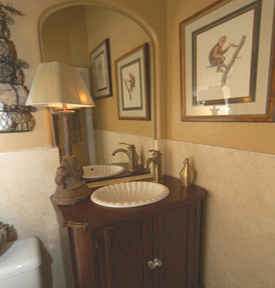 Example of a mid-sized island style powder room design in San Diego with furniture-like cabinets, dark wood cabinets, a one-piece toilet, beige walls, a vessel sink and wood countertops