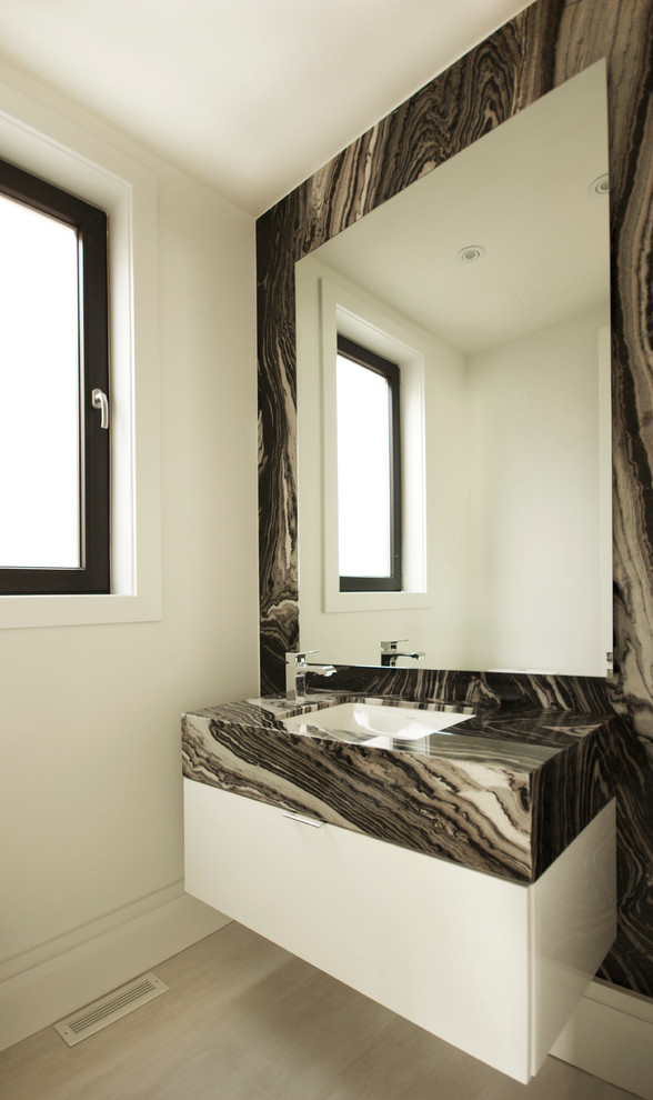 Idee per un piccolo bagno di servizio minimal con lavabo sottopiano, ante lisce, ante bianche, piastrelle grigie, pareti bianche, WC monopezzo, pavimento in gres porcellanato e lastra di pietra