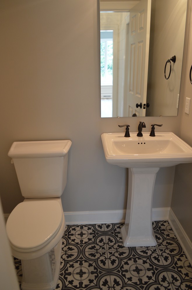 Kleine Klassische Gästetoilette mit Toilette mit Aufsatzspülkasten, beiger Wandfarbe, Keramikboden, Sockelwaschbecken, Mineralwerkstoff-Waschtisch und buntem Boden in Sonstige