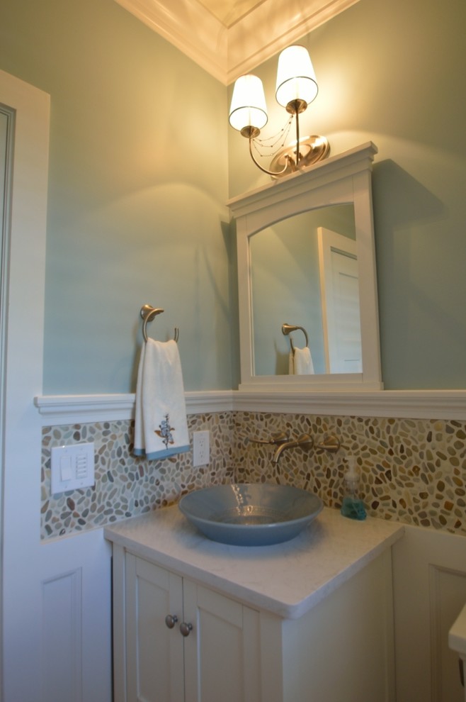 Photo of a traditional cloakroom in New York with a vessel sink, shaker cabinets, white cabinets, engineered stone worktops, a two-piece toilet, multi-coloured tiles, pebble tiles, blue walls and porcelain flooring.