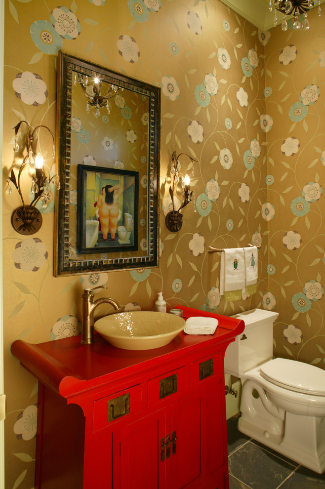 Idée de décoration pour un WC et toilettes bohème avec un placard en trompe-l'oeil, des portes de placard rouges, un sol en ardoise, une vasque et un plan de toilette en bois.
