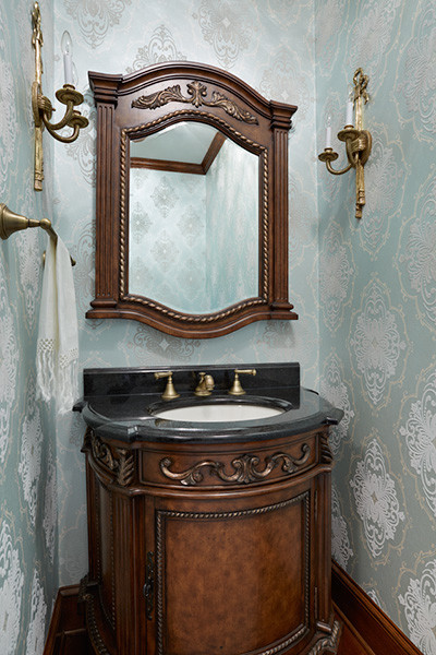 Exemple d'un petit WC et toilettes chic en bois foncé avec un lavabo encastré, un placard en trompe-l'oeil, un plan de toilette en granite, WC à poser et un sol en bois brun.