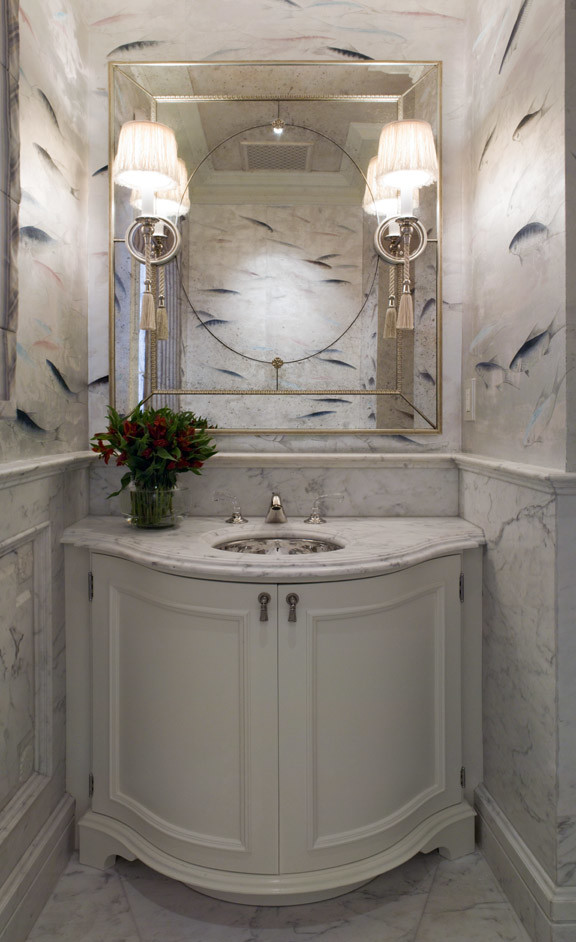 Cette photo montre un WC et toilettes chic de taille moyenne avec un lavabo encastré, des portes de placard blanches, un plan de toilette en marbre, un sol en marbre, un placard en trompe-l'oeil, du carrelage en marbre et un plan de toilette gris.