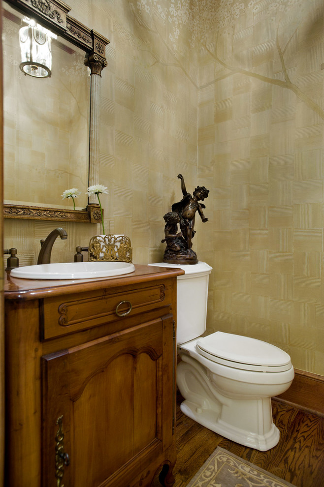 Réalisation d'un WC et toilettes tradition en bois brun avec un placard en trompe-l'oeil, WC séparés, un mur beige, un sol en bois brun, un lavabo posé, un plan de toilette en bois, un sol marron et un plan de toilette marron.
