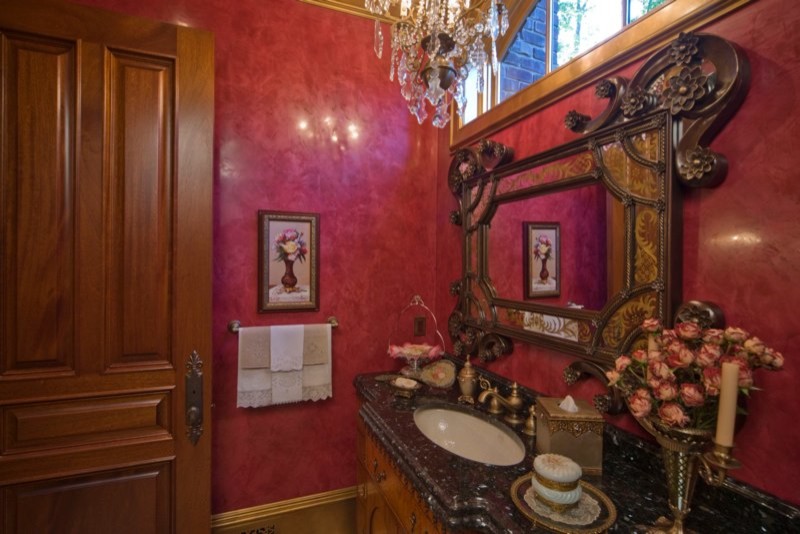 Idées déco pour un grand WC et toilettes éclectique en bois foncé avec un placard en trompe-l'oeil, un mur rouge, un sol en carrelage de porcelaine, un lavabo encastré et un plan de toilette en marbre.