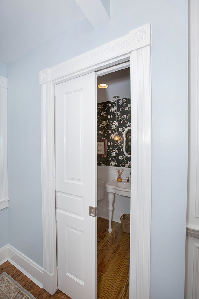 На фото: туалет среднего размера в классическом стиле с фасадами в стиле шейкер, белыми фасадами, раздельным унитазом, синими стенами, паркетным полом среднего тона, раковиной с пьедесталом и коричневым полом с
