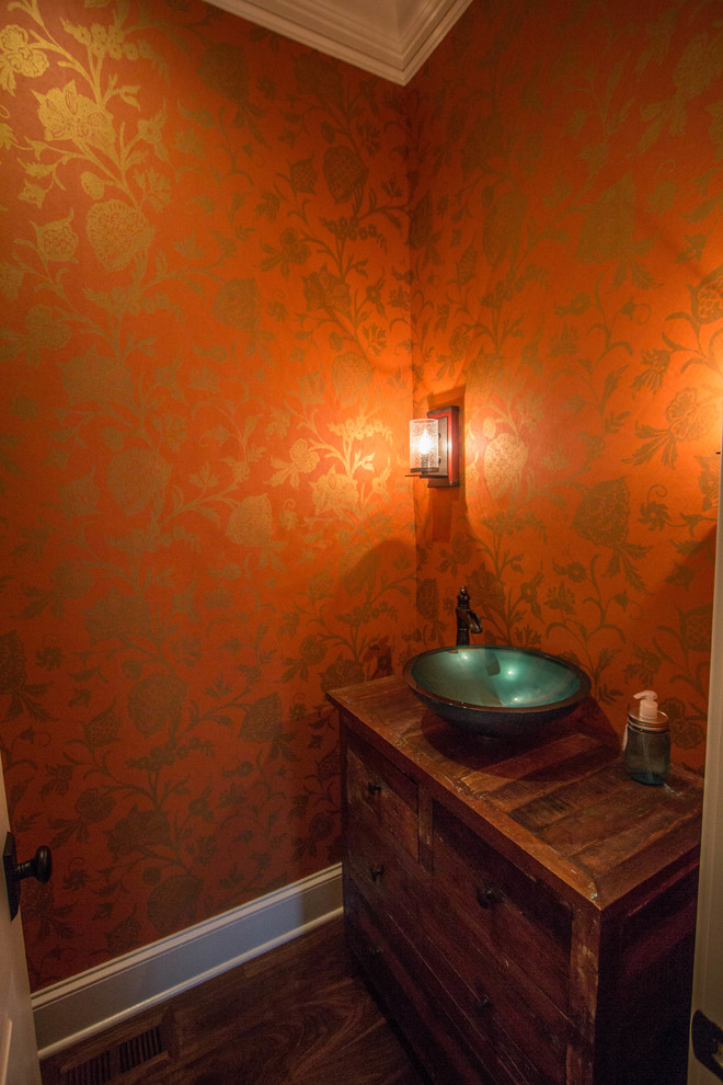 Foto di un bagno di servizio chic con lavabo a bacinella, consolle stile comò, ante con finitura invecchiata, top in legno, pareti arancioni e parquet scuro