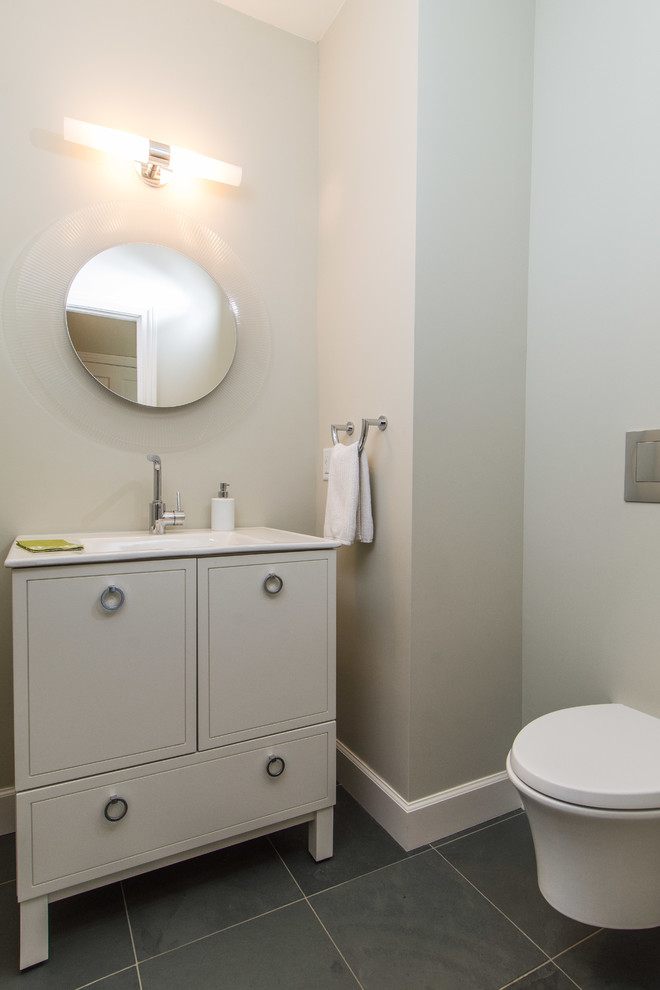 Immagine di un piccolo bagno di servizio moderno con ante con riquadro incassato, ante bianche, WC sospeso, pavimento grigio e top bianco