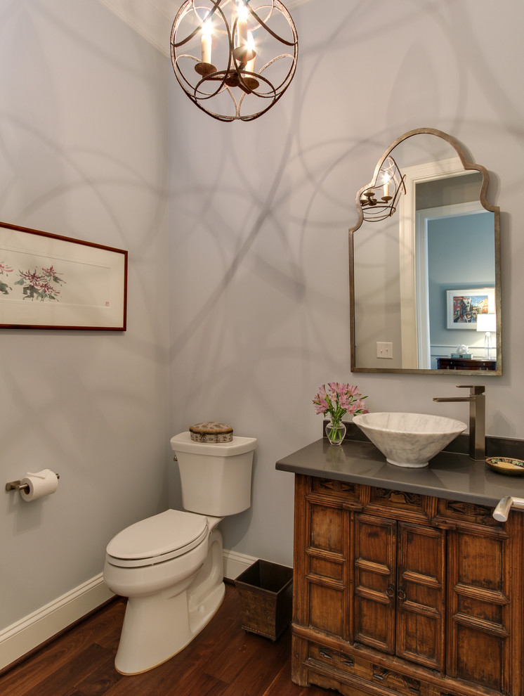 Traditional cloakroom in Raleigh with a vessel sink, freestanding cabinets, medium wood cabinets, engineered stone worktops, a two-piece toilet, grey walls, dark hardwood flooring and white tiles.