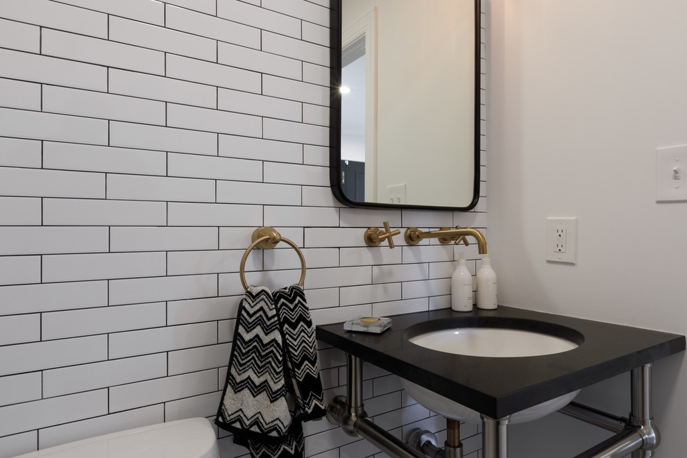 Cette image montre un WC et toilettes traditionnel avec un carrelage blanc, un carrelage métro, un mur blanc, un sol en carrelage de céramique, un lavabo encastré et un sol noir.