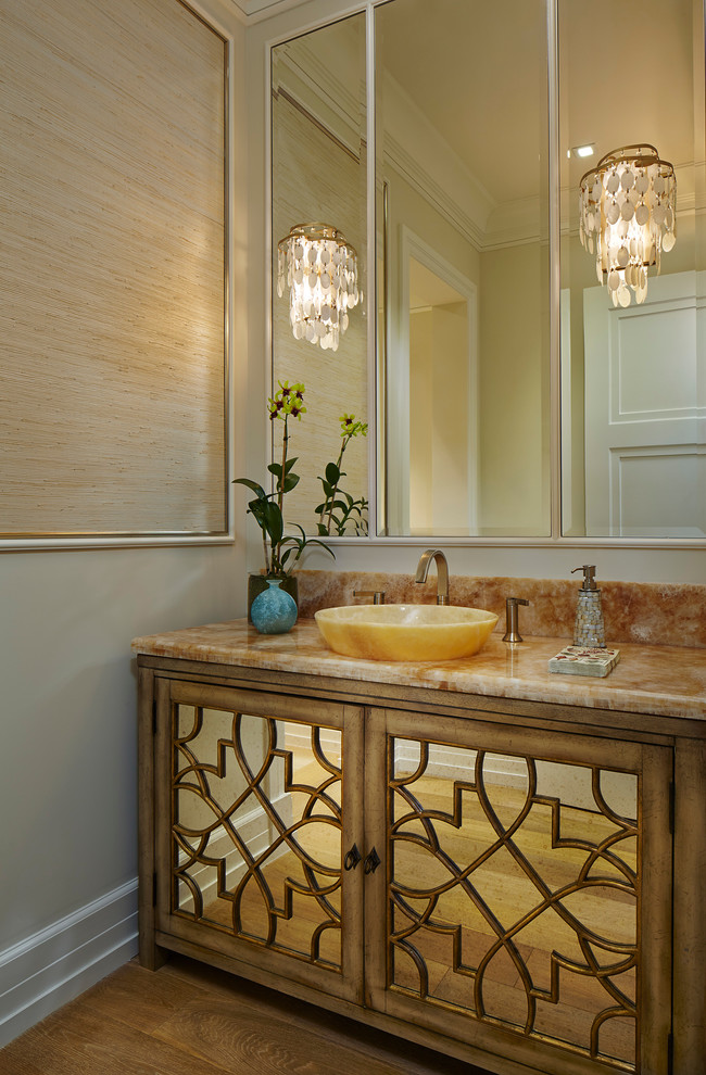 Mediterrane Gästetoilette mit Aufsatzwaschbecken, braunem Holzboden und verzierten Schränken in Miami