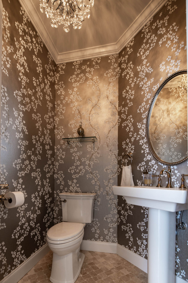 This is an example of a medium sized traditional cloakroom in New York with a two-piece toilet, marble flooring, a pedestal sink, beige floors and a freestanding vanity unit.