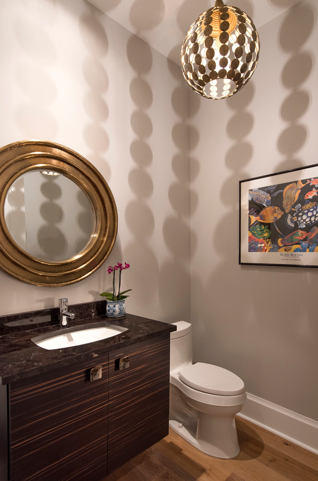 Inspiration for a small traditional cloakroom in Miami with flat-panel cabinets, dark wood cabinets, a one-piece toilet, grey walls, light hardwood flooring, a submerged sink and granite worktops.