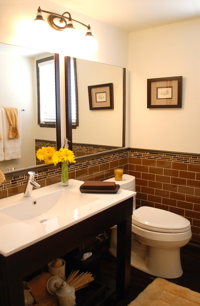 Mittelgroße Klassische Gästetoilette mit Toilette mit Aufsatzspülkasten, braunen Fliesen, weißer Wandfarbe, dunklem Holzboden, integriertem Waschbecken, Mineralwerkstoff-Waschtisch, dunklen Holzschränken, offenen Schränken und Metrofliesen in Los Angeles