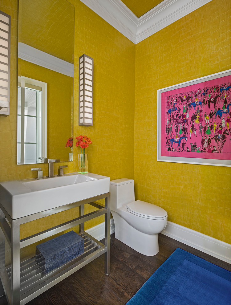 На фото: туалет среднего размера в стиле неоклассика (современная классика) с открытыми фасадами, унитазом-моноблоком, желтыми стенами, темным паркетным полом, консольной раковиной и коричневым полом