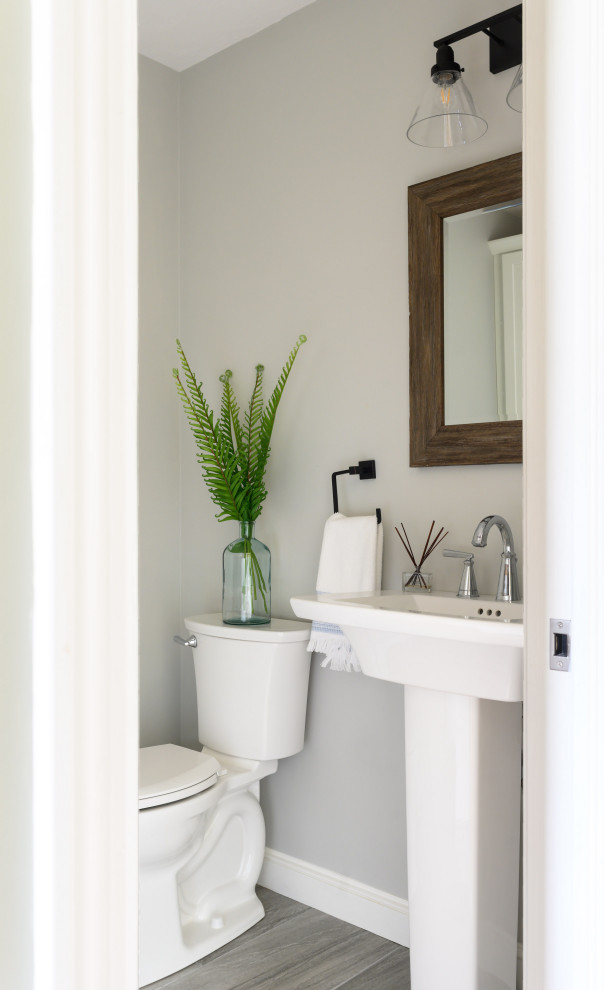 На фото: туалет в стиле неоклассика (современная классика) с серыми стенами, раковиной с пьедесталом и серым полом с