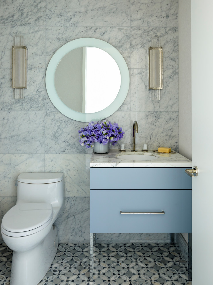 Cette image montre un WC et toilettes traditionnel avec un placard à porte plane, des portes de placard bleues, WC à poser, un carrelage gris, un lavabo encastré, un sol gris, un plan de toilette blanc et meuble-lavabo sur pied.