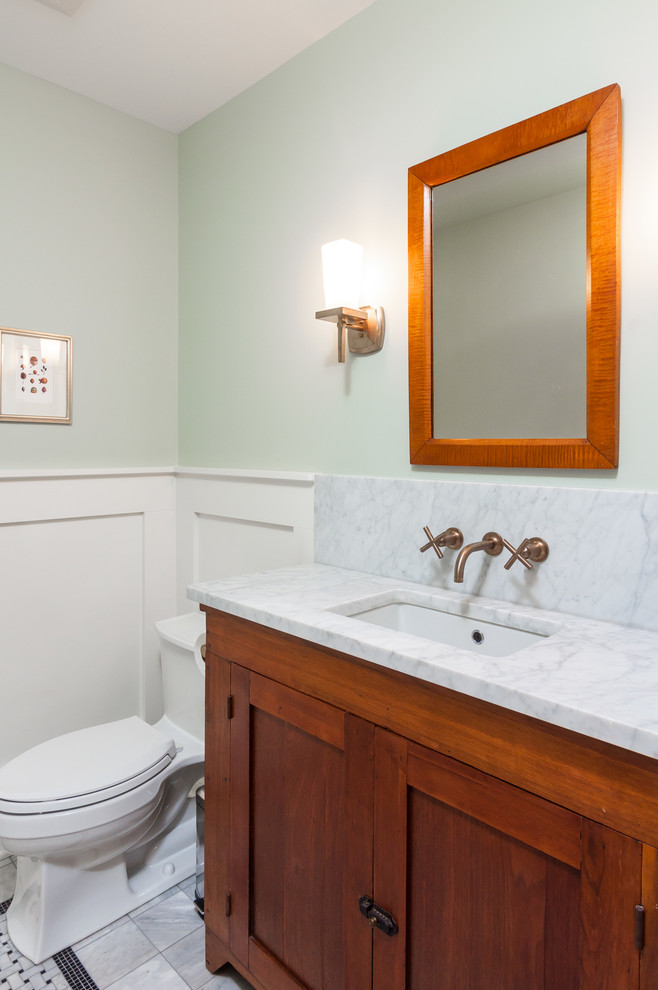 Cette image montre un petit WC et toilettes traditionnel en bois brun avec un lavabo encastré, un placard avec porte à panneau encastré, un plan de toilette en quartz, WC à poser, un carrelage gris, un mur vert et un sol en carrelage de céramique.