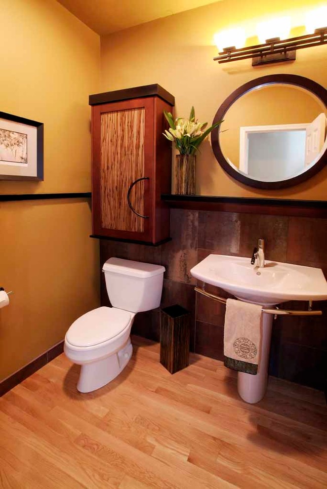 Foto di un bagno di servizio tradizionale di medie dimensioni con ante in stile shaker, ante in legno scuro, WC a due pezzi, pareti beige, parquet chiaro e lavabo a colonna