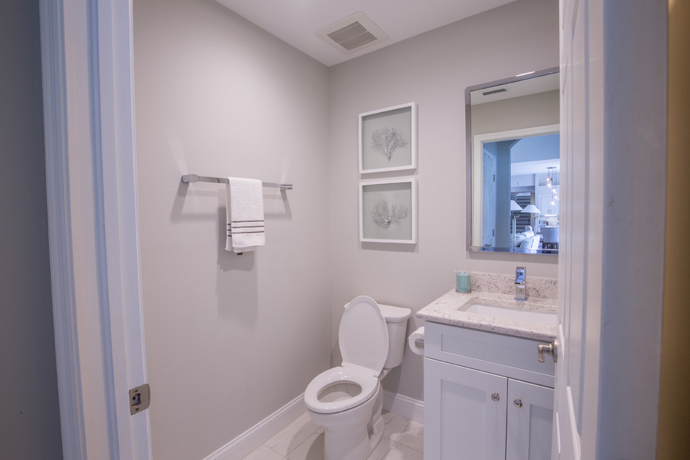 Esempio di un bagno di servizio tradizionale di medie dimensioni con ante in stile shaker, ante bianche, WC a due pezzi, pareti beige, pavimento con piastrelle in ceramica, lavabo sottopiano e top in granito