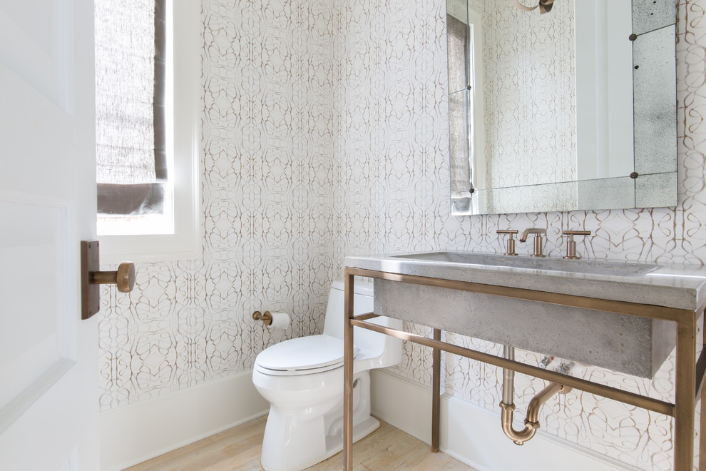 Immagine di un bagno di servizio industriale con WC monopezzo, pareti bianche, parquet chiaro, lavabo integrato, top in cemento e pavimento marrone