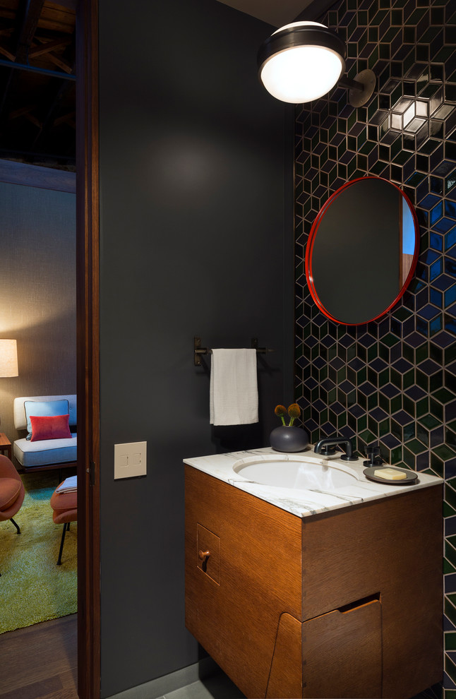 Пример оригинального дизайна: туалет в стиле лофт с фасадами цвета дерева среднего тона, керамической плиткой и мраморной столешницей