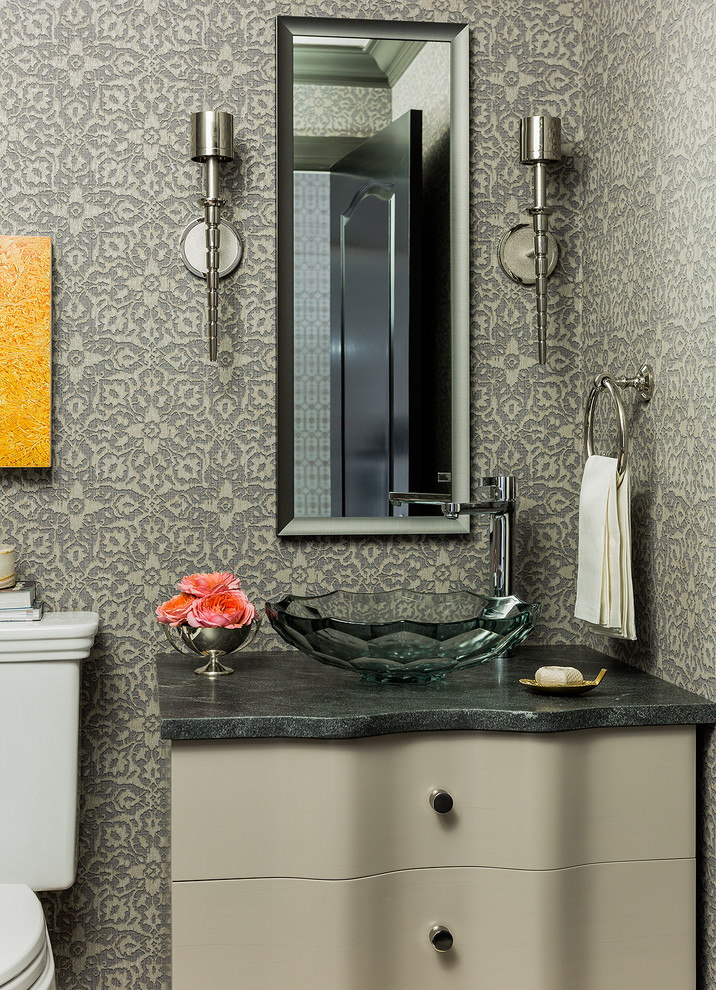 Imagen de aseo clásico con lavabo sobreencimera, armarios tipo mueble, puertas de armario grises y paredes multicolor