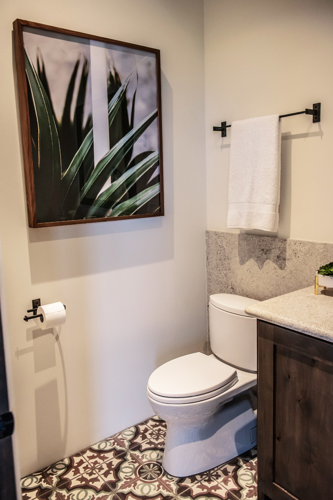 Inredning av ett klassiskt litet beige beige toalett, med skåp i mörkt trä, en toalettstol med hel cisternkåpa, beige väggar, cementgolv, ett undermonterad handfat, granitbänkskiva och flerfärgat golv