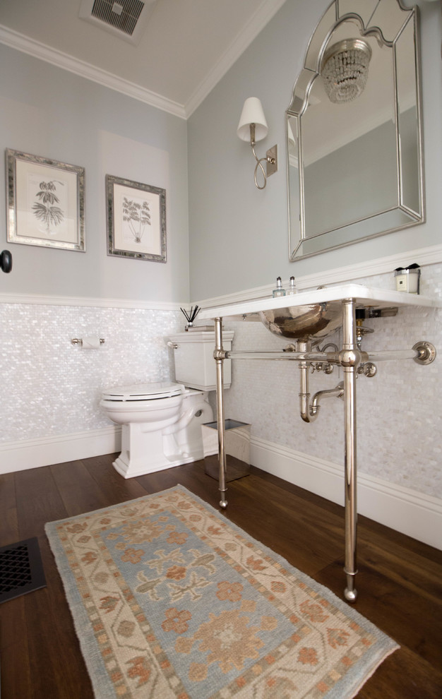 Foto på ett litet vintage toalett, med möbel-liknande, en toalettstol med separat cisternkåpa, vit kakel, mosaik, blå väggar, mellanmörkt trägolv, ett piedestal handfat och bänkskiva i akrylsten
