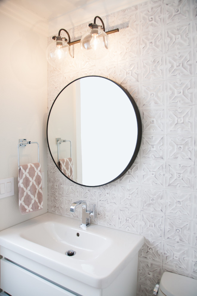 オレンジカウンティにある高級な巨大なコンテンポラリースタイルのおしゃれなトイレ・洗面所 (フラットパネル扉のキャビネット、白いキャビネット、一体型トイレ	、セラミックタイル、壁付け型シンク、白い床) の写真