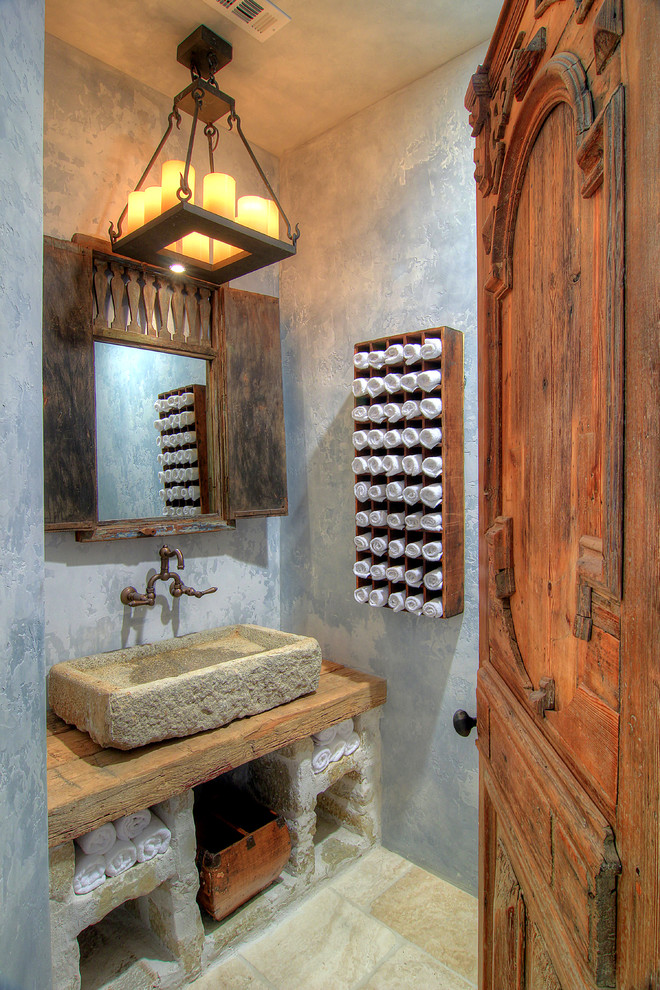 ヒューストンにある地中海スタイルのおしゃれなトイレ・洗面所 (ベッセル式洗面器、木製洗面台、グレーの壁、ブラウンの洗面カウンター) の写真