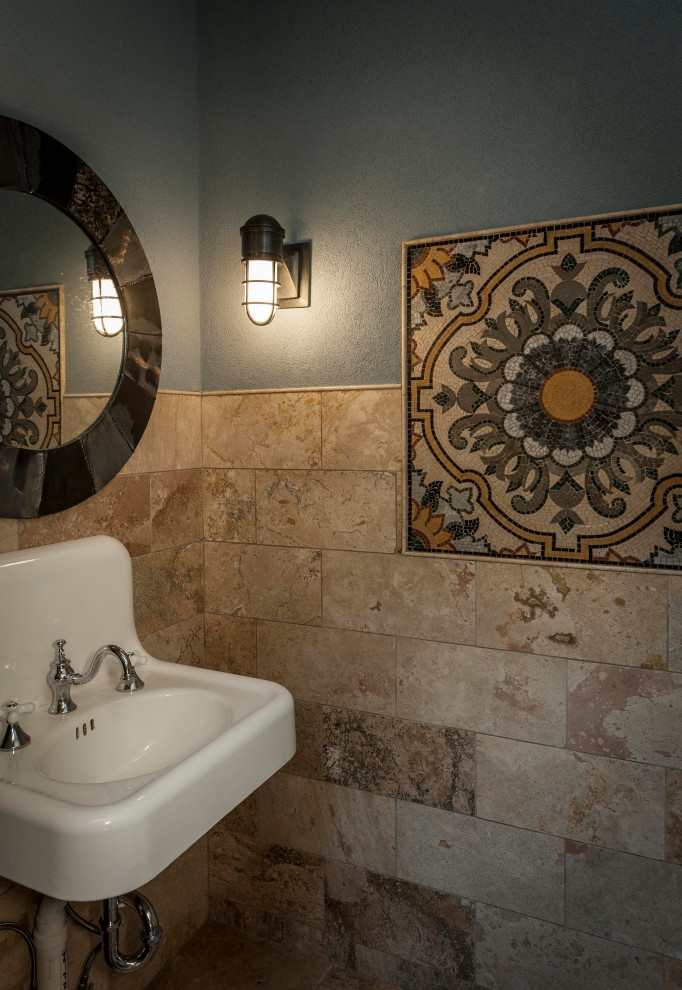 На фото: маленький туалет в средиземноморском стиле с коричневой плиткой, плиткой из травертина, полом из известняка, подвесной раковиной и кирпичными стенами для на участке и в саду