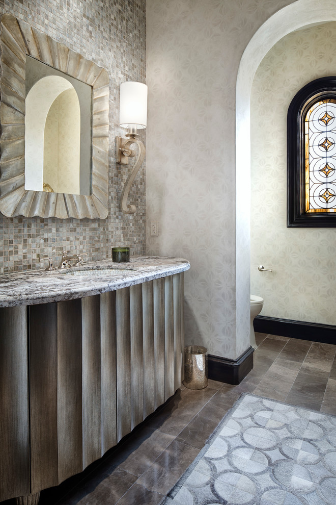 Cette photo montre un WC et toilettes méditerranéen avec un lavabo encastré, un placard en trompe-l'oeil, mosaïque, un mur gris et un carrelage gris.