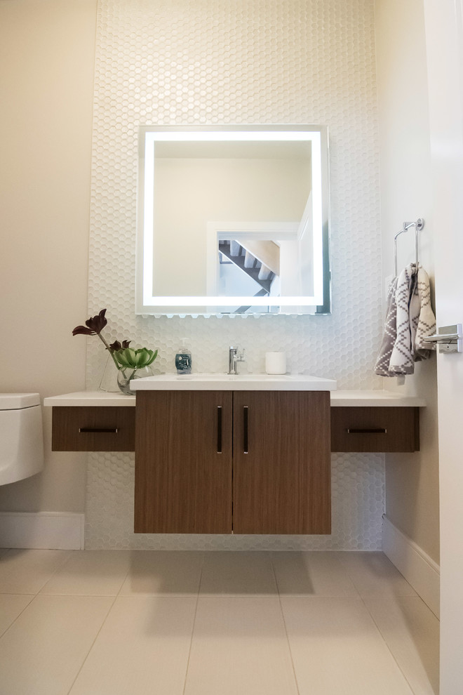 Powder room - mid-sized contemporary white tile and mosaic tile porcelain tile and beige floor powder room idea in Edmonton with flat-panel cabinets, dark wood cabinets, a one-piece toilet, beige walls, an undermount sink, solid surface countertops and white countertops