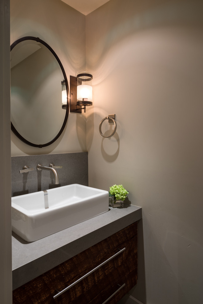 Foto di un bagno di servizio minimal di medie dimensioni con ante lisce, ante in legno bruno, pareti beige, top in superficie solida, lavabo a bacinella e top grigio