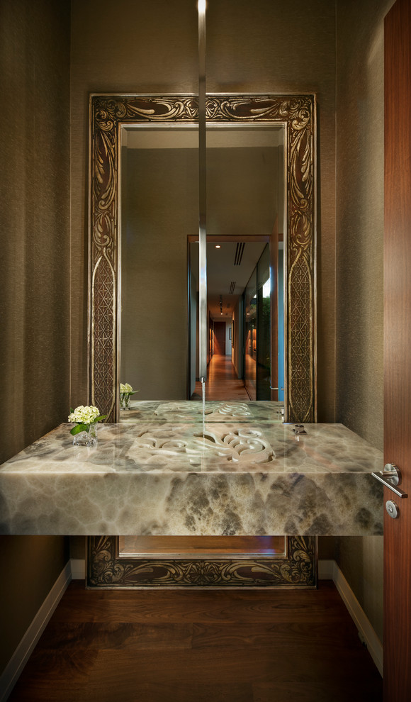 Moderne Gästetoilette mit integriertem Waschbecken, brauner Wandfarbe, dunklem Holzboden und grauer Waschtischplatte in Phoenix