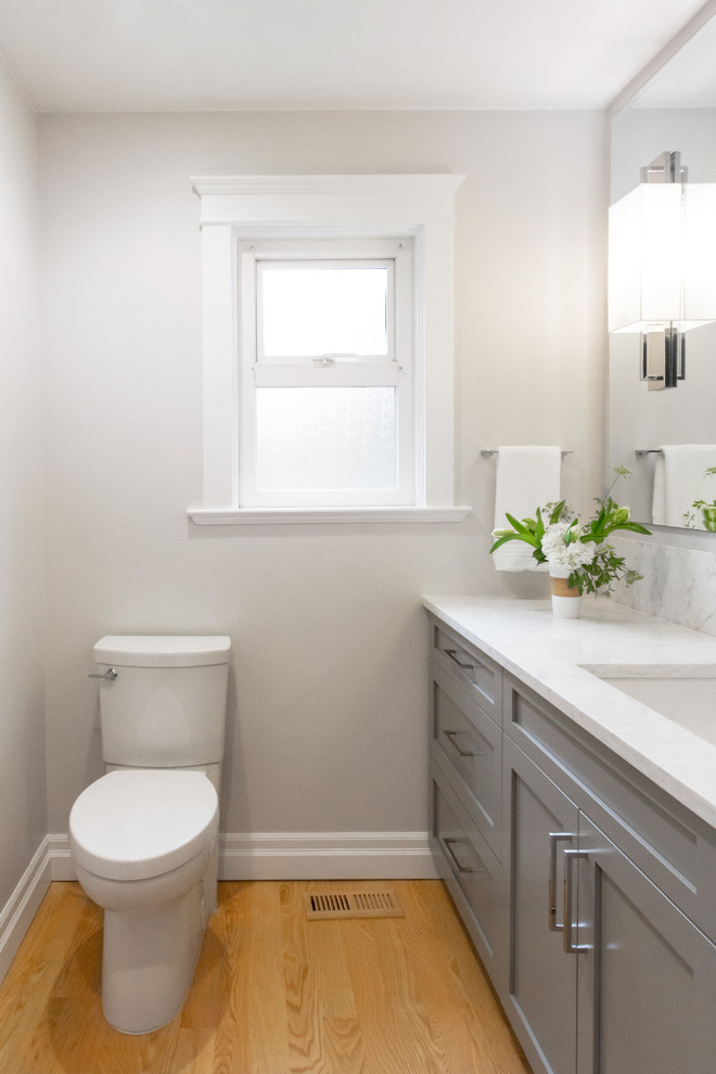 Design ideas for a small classic cloakroom in Vancouver with shaker cabinets, grey cabinets, grey walls, light hardwood flooring, a submerged sink and engineered stone worktops.
