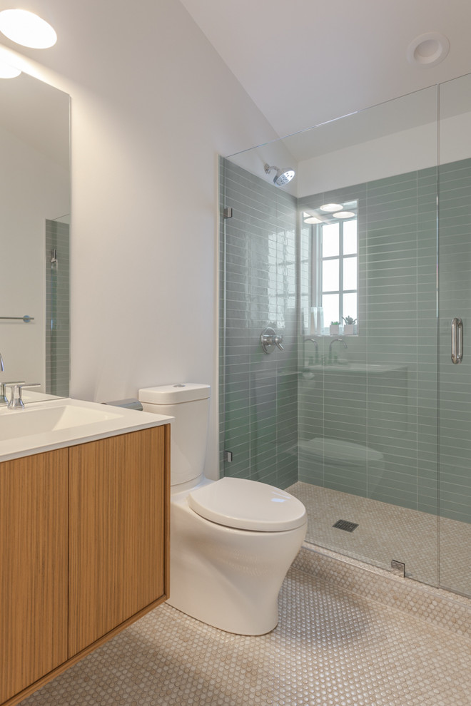 This is an example of a small modern bathroom in Denver with flat-panel cabinets, light wood cabinets, a one-piece toilet, green tiles, porcelain tiles, white walls, ceramic flooring, an integrated sink, engineered stone worktops and beige floors.